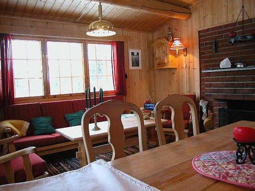ein Esszimmer mit Tisch und Stühlen und einem Kamin in der Unterkunft Koselig, lita hytte på Aurdalsåsen ved Danebu in Aurdal