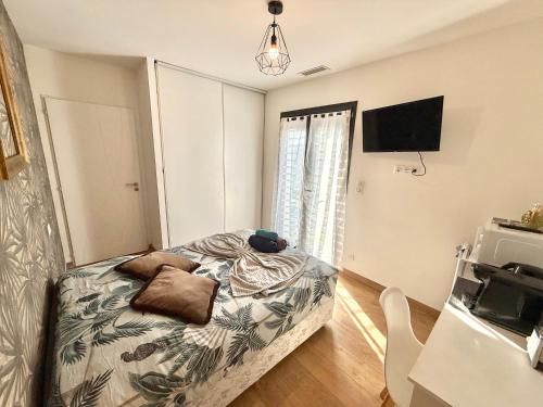 une chambre avec un lit et une télévision à écran plat dans l'établissement Studio Cosy - CLIM & Parking & WIFI, à Aucamville