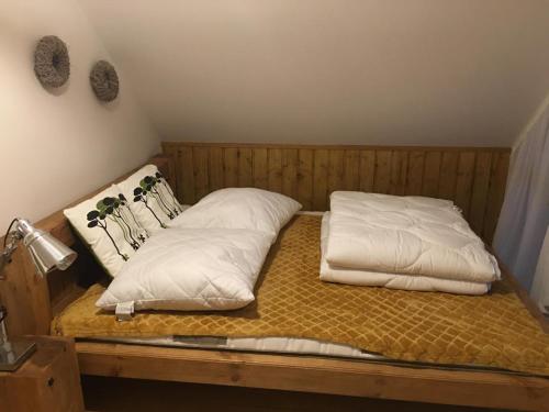 a bed with two pillows on top of it at Nowoczesny dom wakacyjny "Sole" nad jeziorem Gwiazdy, Ostoja Bukowo, Borowy Młyn, Kaszuby, region Gochy, z dala od miasta, dookoła lasy in Borowy Młyn