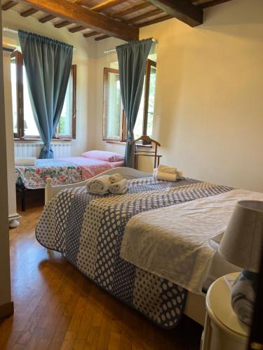 a bedroom with two beds with blue drapes at Tenuta Gran Bosco in Loro Piceno