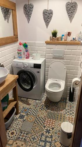 a bathroom with a washing machine and a toilet at Nowoczesny dom wakacyjny "Sole" nad jeziorem Gwiazdy, Ostoja Bukowo, Borowy Młyn, Kaszuby, region Gochy, z dala od miasta, dookoła lasy in Borowy Młyn