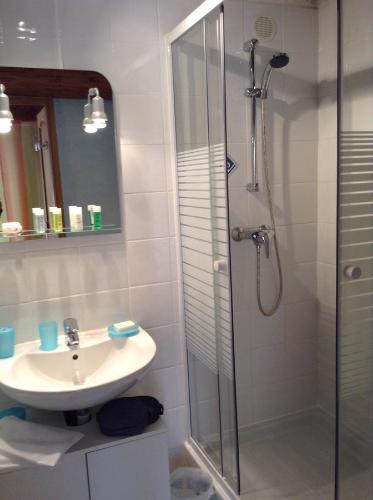 a bathroom with a sink and a glass shower at Chinchon in LʼIsle-sur-la-Sorgue