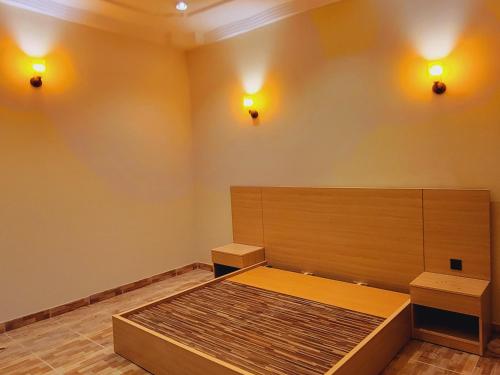 a room with a bed and two lights on the wall at New millennium Guest House in Dargai