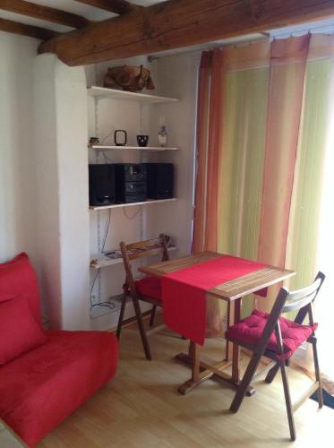 a living room with a table and chairs and a couch at Chinchon in LʼIsle-sur-la-Sorgue