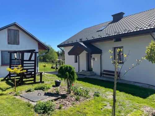 a house with a garden in front of it at Roztocze agroturystyka - domek dla całej rodziny in Bełżec
