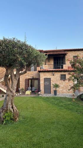 a brick house with a tree in the yard at Studio Greek Mansion in Nea Moudania