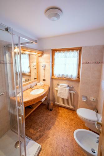 a bathroom with a sink and a shower and a toilet at Alpi & Golf Hotel in Bormio