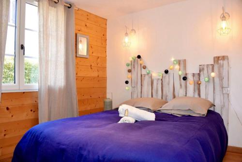 une chambre avec un grand lit avec des draps violets dans l'établissement Chambres de charme, à Lège-Cap-Ferret