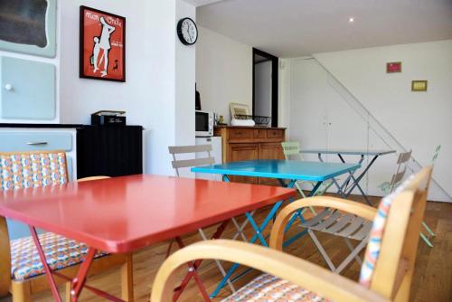 - une cuisine avec deux tables et des chaises dans une pièce dans l'établissement Chambres de charme, à Lège-Cap-Ferret