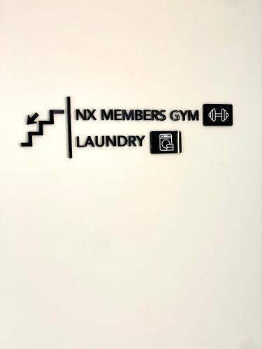 a street sign with the words norwegian members gym laundry at THE NIXON Luxury Suites and Apartment Hotel in Athens