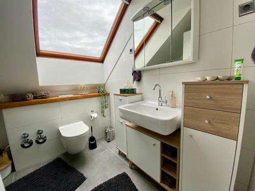 Un baño con lavabo, inodoro y ventana. en Auszeitwohnung, en Lage