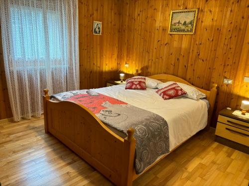 een slaapkamer met een bed in een kamer met houten wanden bij Mes Lastei in Campitello di Fassa