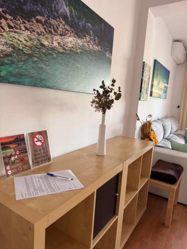 a wooden desk in a room with a vase of flowers at Apartamento Playa Victoria in Cádiz