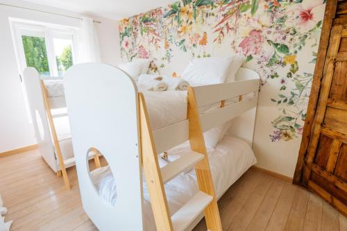 une chambre avec des lits superposés et un mur fleuri dans l'établissement Terre de Partages, à Saint-Bris-le-Vineux