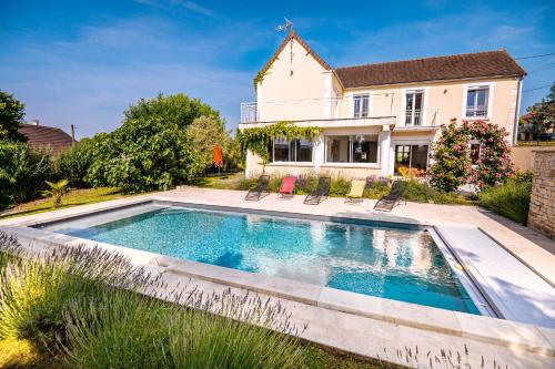 une piscine devant une maison dans l'établissement Terre de Partages, à Saint-Bris-le-Vineux