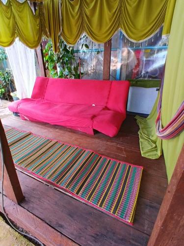 a pink couch sitting on the floor of a room at Cassa Bonda Std Triple Room in Machang