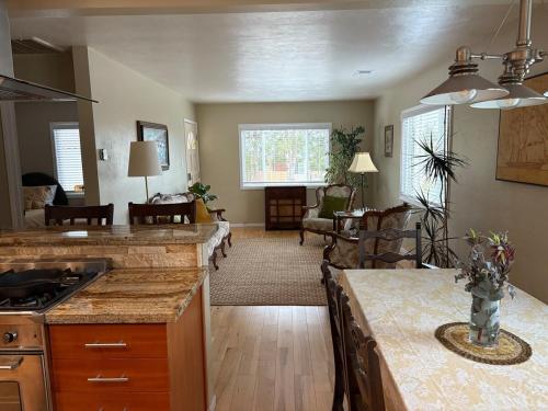 a kitchen with a counter top and a living room at Seaside Garden Escape, A Stroll to the Beach! in Grover Beach