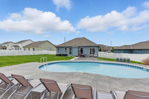 a swimming pool with chairs and a house at Spacious Country Farmhouse Retreat, Sleeps 16, Pool, Movie Room in Papillion