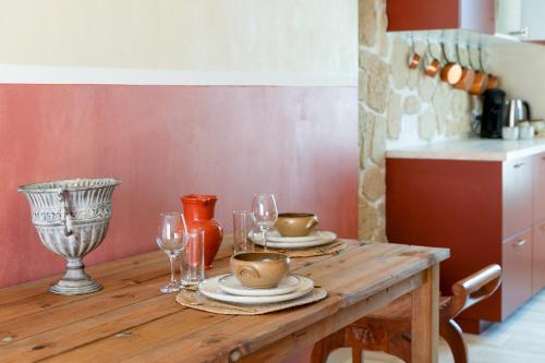 une table en bois avec des assiettes et des verres à vin dessus dans l'établissement L'Escale Romaine, à Orange