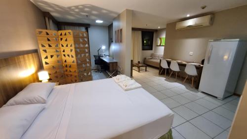 ブラジリアにあるApartHotel - Nobile Suites Monumental Brasíliaの大きなベッドとリビングルームのある寝室