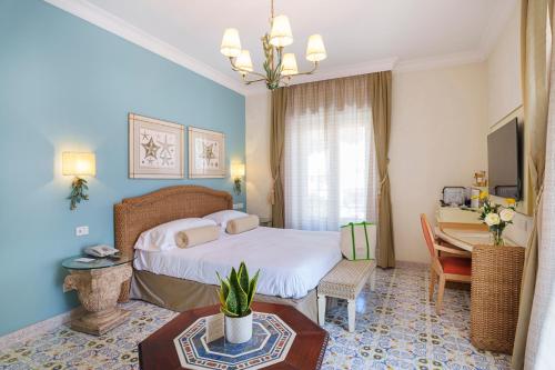 a bedroom with a bed and a desk and a table at Manzi Hotel & Spa in Ischia
