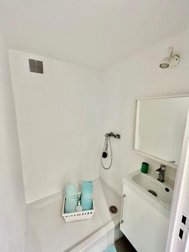 une salle de bain blanche avec un lavabo et un miroir dans l'établissement Refuge mediteraneen, à La Ciotat