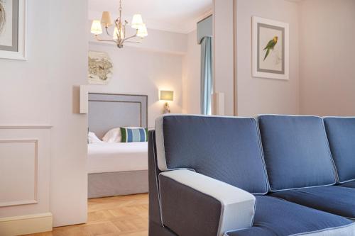 a blue couch in a room with a bedroom at Manzi Hotel & Spa in Ischia