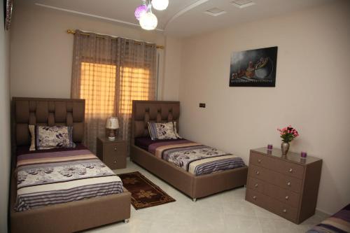 a bedroom with two beds and a window at Lilia-appart Luxe et confort in Oujda