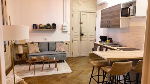 un salon avec un canapé et une table dans une cuisine dans l'établissement CHARME 1850, climatisé et cinéma, à Montpellier