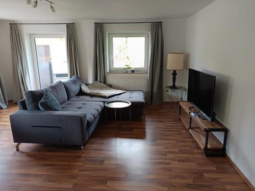 a living room with a couch and a flat screen tv at Lodge Ehrenberg in Ehenbichl