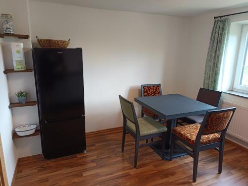 a dining room with a black table and chairs at Lodge Ehrenberg in Ehenbichl