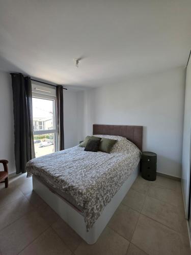 une chambre avec un lit et une fenêtre dans l'établissement 2 chambres appartements 5 minutes des plages, à Vescovato