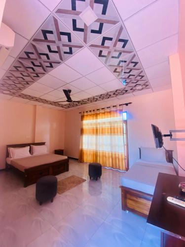 a room with two beds and a table and chairs at Woodnest Saayoo Resort in Negombo
