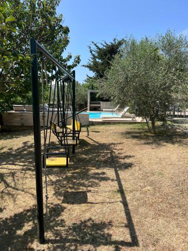 a swing set in a yard with a pool at Holiday HOME Zadar DIKLO in Zadar