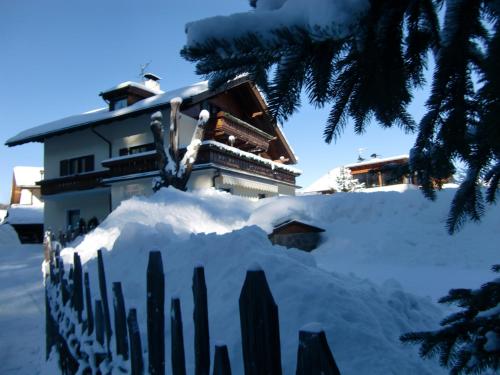 a house with a pile of snow in front of it at Residence Linde - Ferienwohnungen & Apartments in Castelrotto