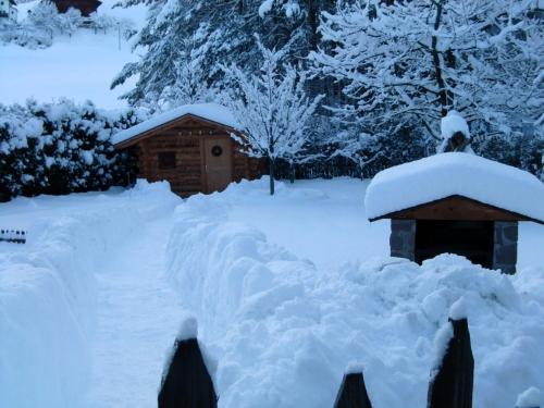 a yard covered in snow with a small house at Residence Linde - Ferienwohnungen & Apartments in Castelrotto