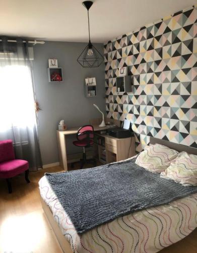 une chambre avec un grand lit et un bureau dans l'établissement Le cocon de Stef, à Salies-de-Béarn