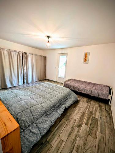 une chambre avec deux lits et un parquet dans l'établissement Le Gîte d'Entressen Piscine Jeux & Pétanque Istres Miramas, à Entressen