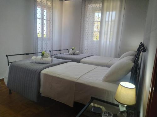 two beds in a room with two windows at Villa Makris in Zenempisátika