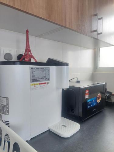 a microwave in a kitchen with the eiffel tower at KLIA Travel Homestay - 3R 2B - WIFI & NETFLIX in Sepang