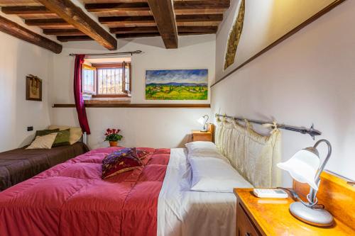 a bedroom with a bed and a desk with a lamp at La Casa di Gelsomino in Massa Martana