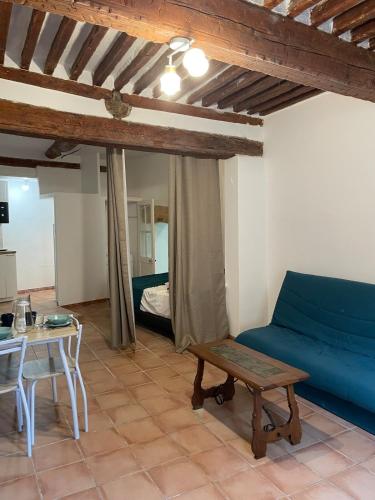 un salon avec un canapé bleu et une table dans l'établissement Plaisir de vacances, à Aix-en-Provence
