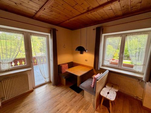 a room with a table and two windows at Residence Linde - Ferienwohnungen & Apartments in Castelrotto