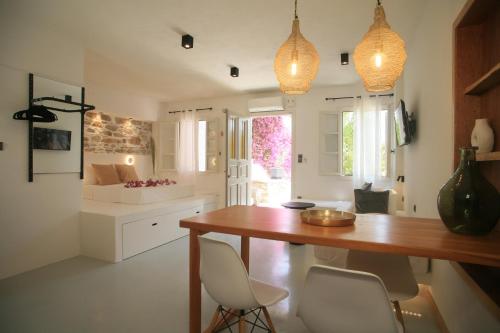 una cucina con tavolo in legno e sedie bianche di Axilleion Boutique Hotel a Ermoupoli