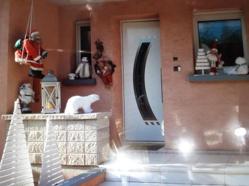 une maison de jouets avec un chat blanc assis à côté d'une porte dans l'établissement Christiane and Danys cottage Nice apartment for 4 people, à Munster