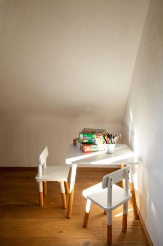a white desk with two chairs and a table with books at Golavškov mlin in Prebold