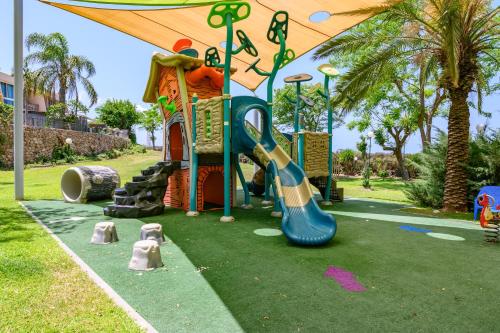 a playground with a slide in a park at Royal Suite Caesarea in Caesarea