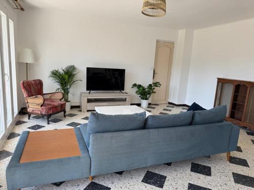 un salon avec un canapé bleu et une télévision dans l'établissement 75 m2 2-bedroom apartment in Toulon, à Toulon