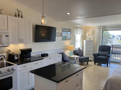 a kitchen with white cabinets and a black counter top at The Braemar Condominium in North Truro