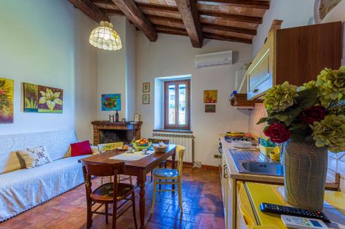 a kitchen and living room with a table and a sink at La Casa di Gelsomino in Massa Martana